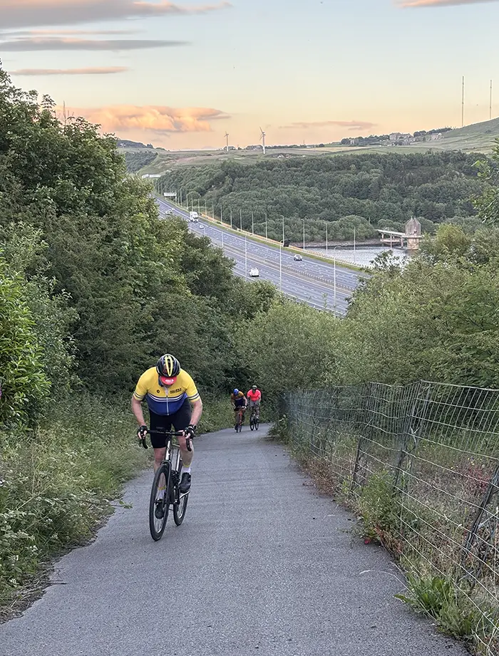 Cyclist beside a reservoir at sunrise